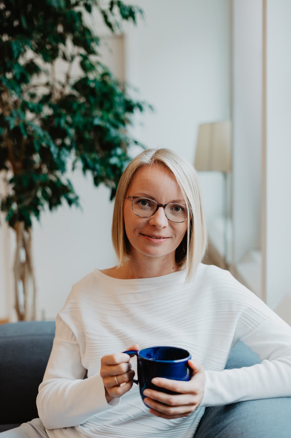 Maria-Kosmala-Bazi-Beratung-Einladung Maria Kosmala mit blauer Kaffeetasse auf dem Sofa – freundliche Einladung zur tief gehenden Bazi Beratung oder zum Bazi lernen in der Bazi Wisdom Academy®