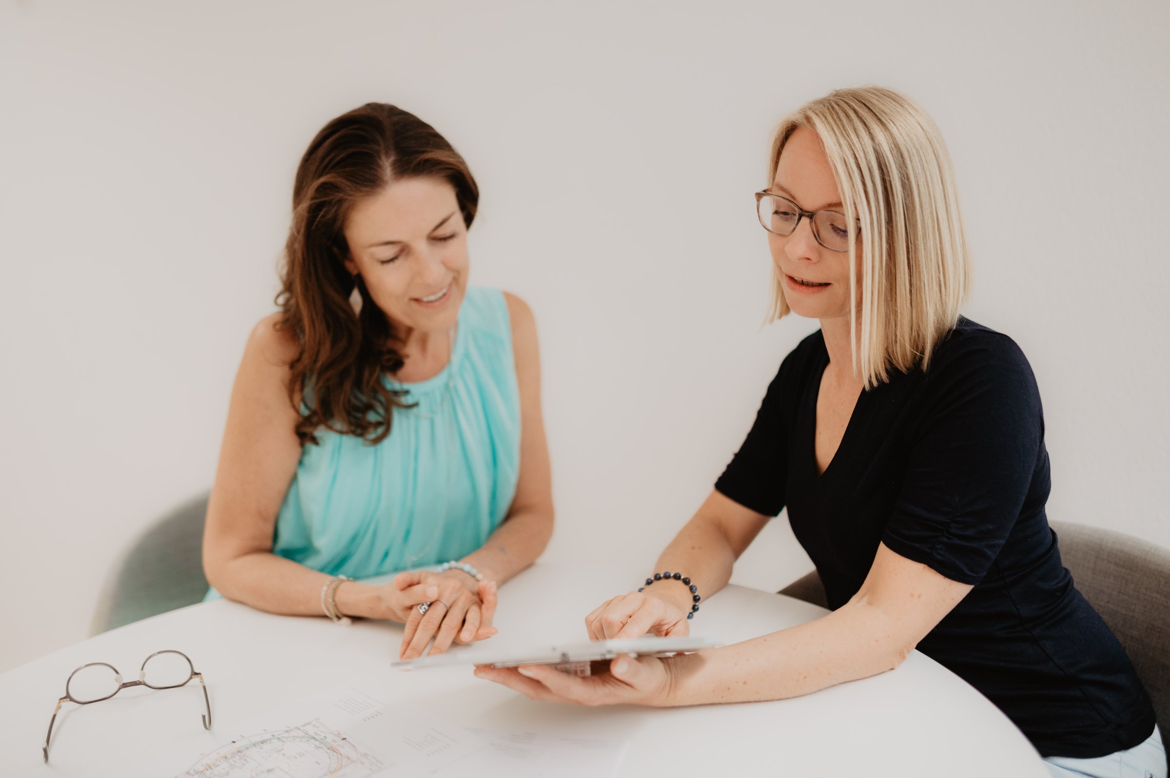 Zwei Frauen sitzen an einem Tisch und besprechen gemeinsam ein Bazi Chart – eine Bazi Wisdom Beratung im vertrauten Gespräch