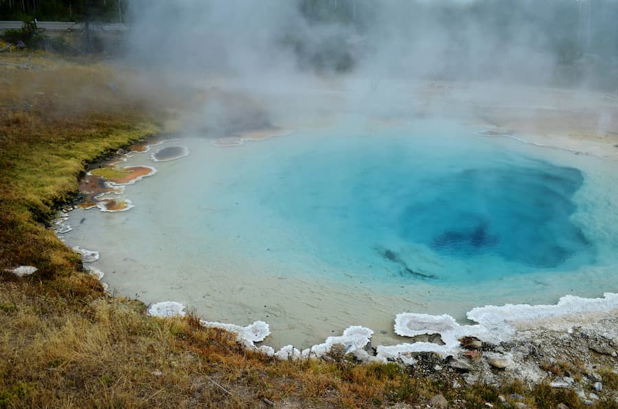 Sanft dampfende heiße Quelle mit türkisblauem Wasser in natürlicher Umgebung – Symbol für innere Wahrheit und achtsame Wandlung im Juni 2025.